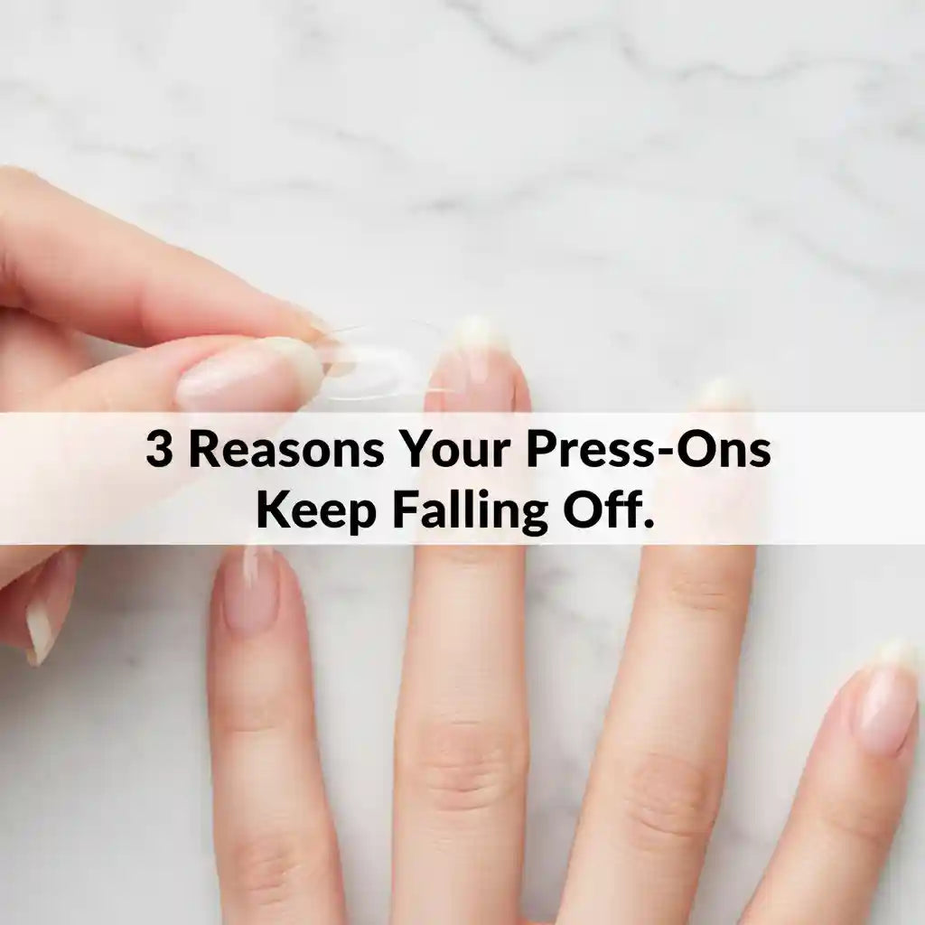 Hand peeling off a press-on nail revealing the natural nail underneath on white marble surface, with text overlay: 3 Reasons Your Press-Ons Keep Falling Off — MOONLEE press-on nail troubleshooting guide
